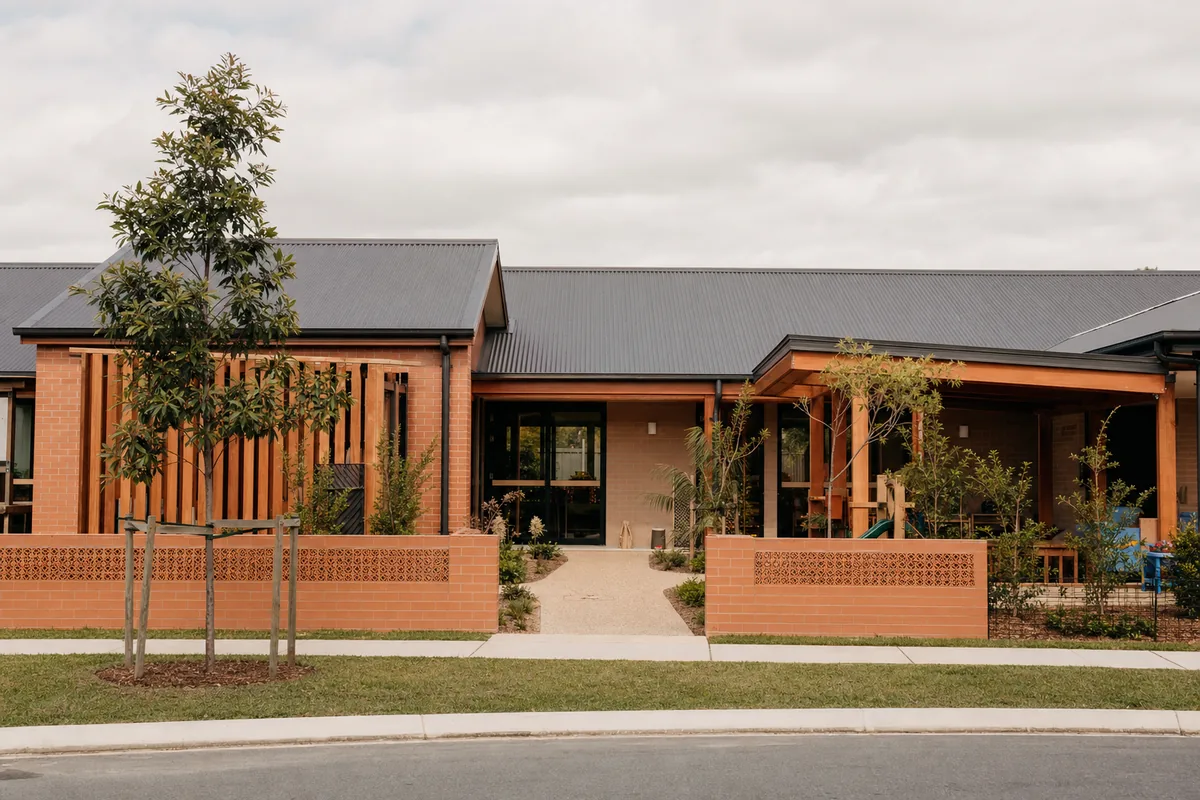 Completed single storey childcare centre with warm face brick walls and timber battens.