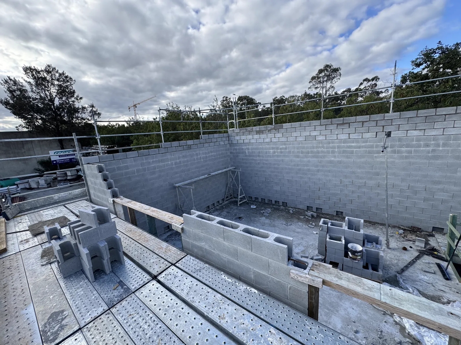 Internal concrete blockwork walls to a large commercial floor plate with a tower crane on the skyline.