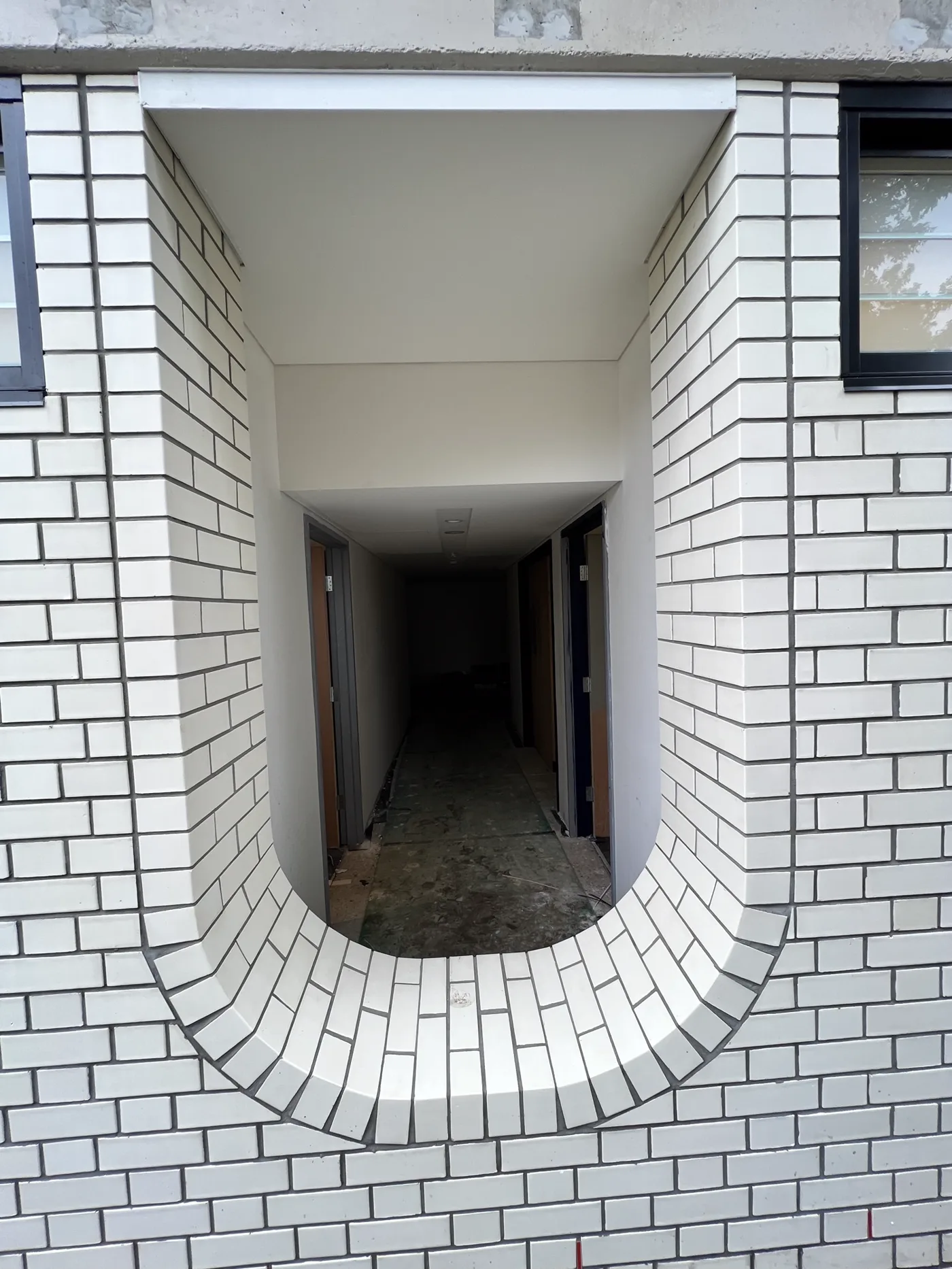 Elliptical white face-brick doorway reveal with radial brick sill at St Margaret's Anglican Girls School, Ascot.