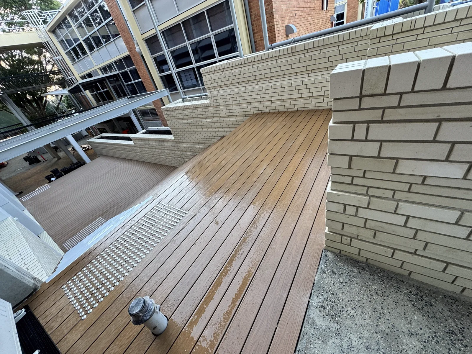 Raked-bond white brickwork to an elevated deck surround, with feature quoin returns and precise joint alignment.