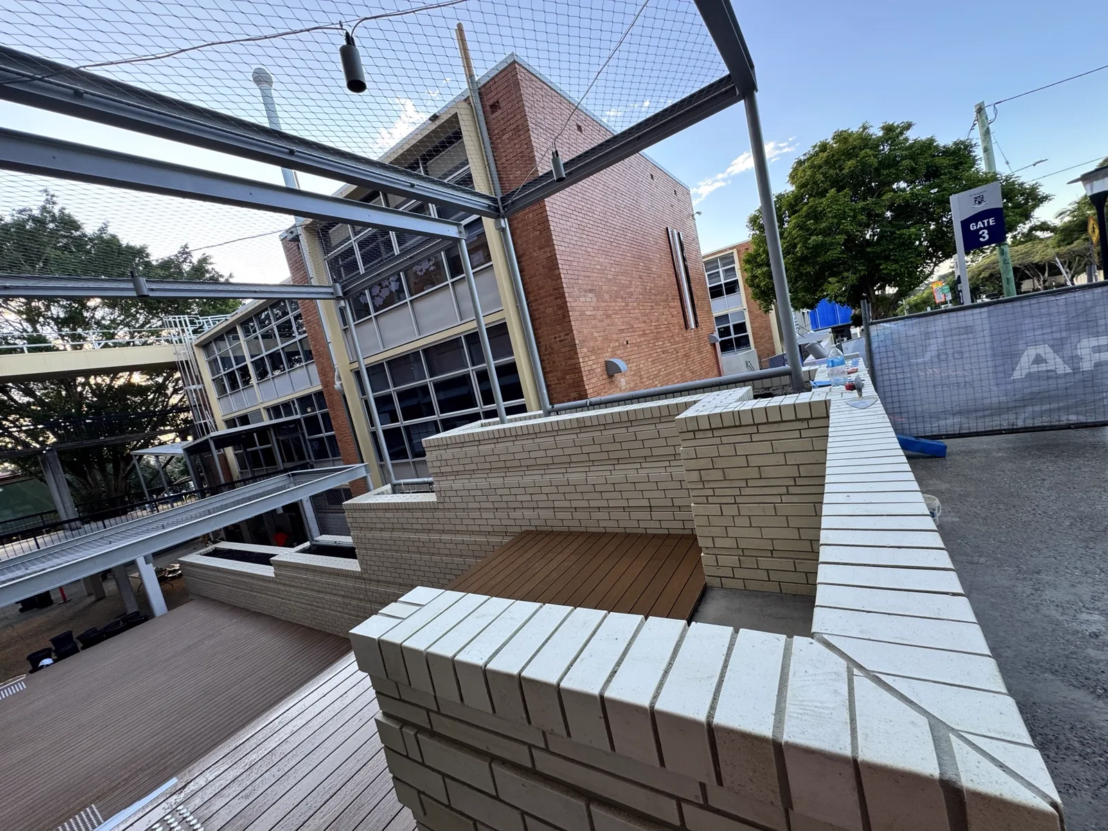 Brick bench surrounds and screen walls to a courtyard terrace, with soldier-course capping laid to fall.