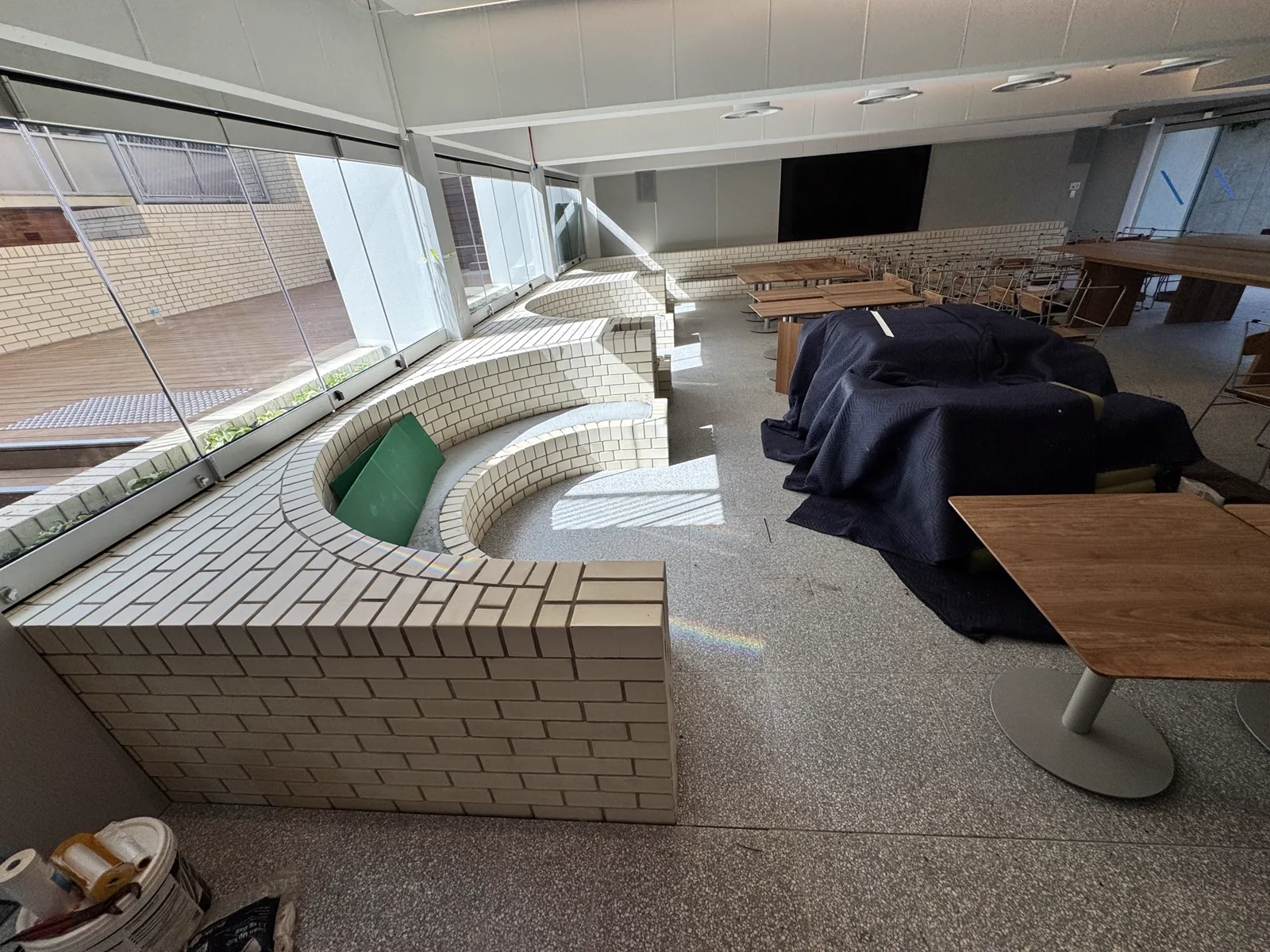 Curved internal brick seating and balustrade to a dining hall, with mixed bond feature panels.